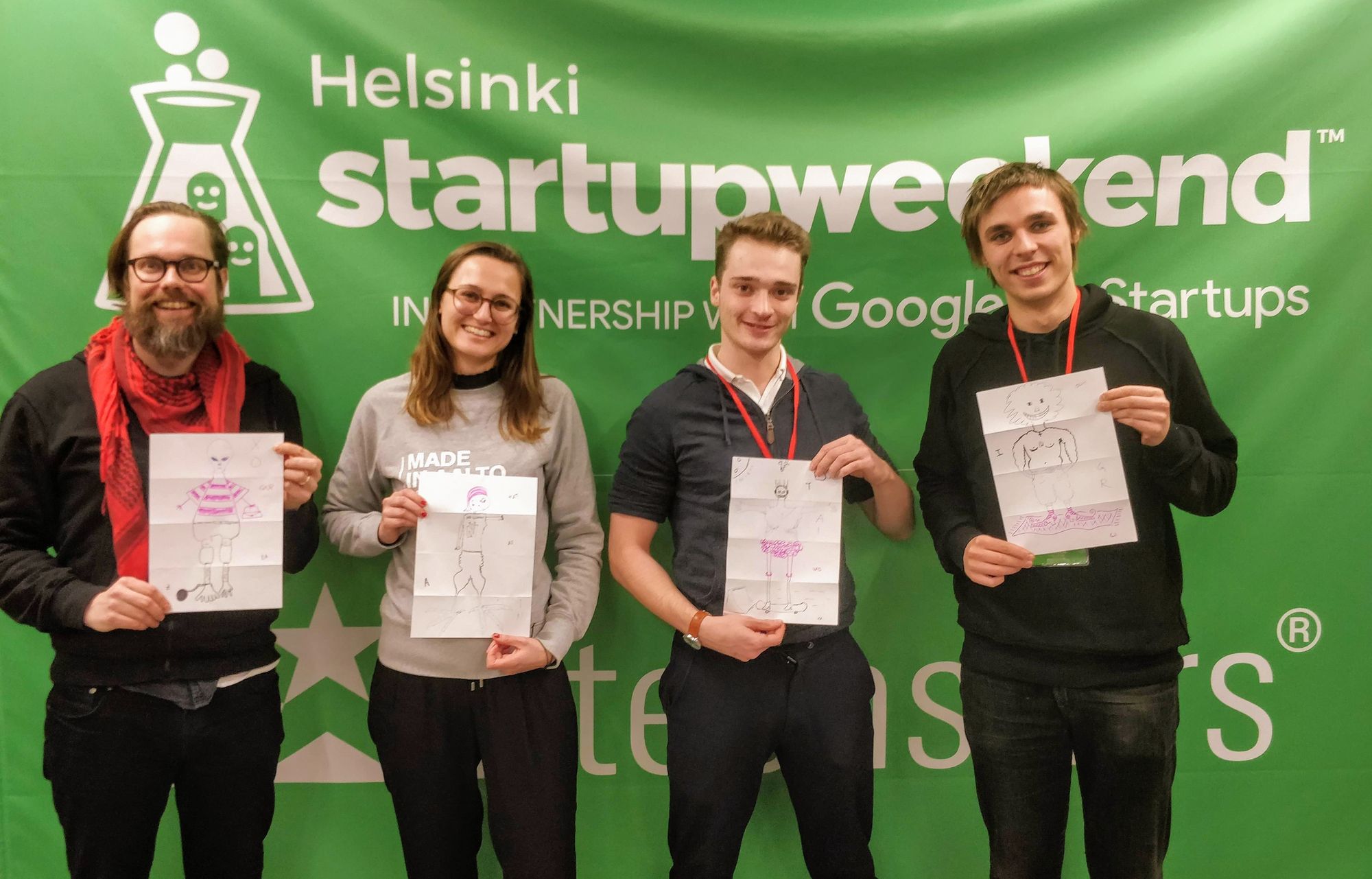 Photo of our Ilo Assist team posing in front of the startup weekend banner.